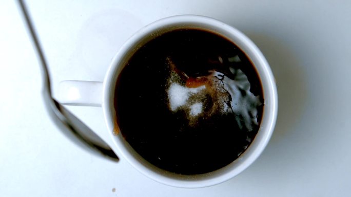 慢动作，用茶匙将糖倒入咖啡中