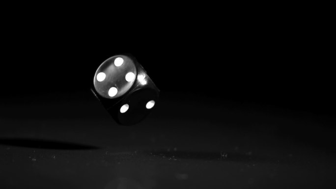 一颗黑色的骰子掉落转动特写