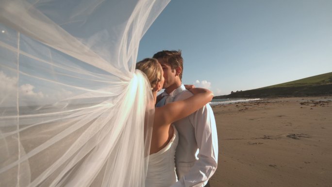 一对新婚夫妇在海滩接吻特写