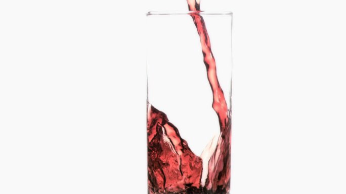 红色液体倒入玻璃杯中特写