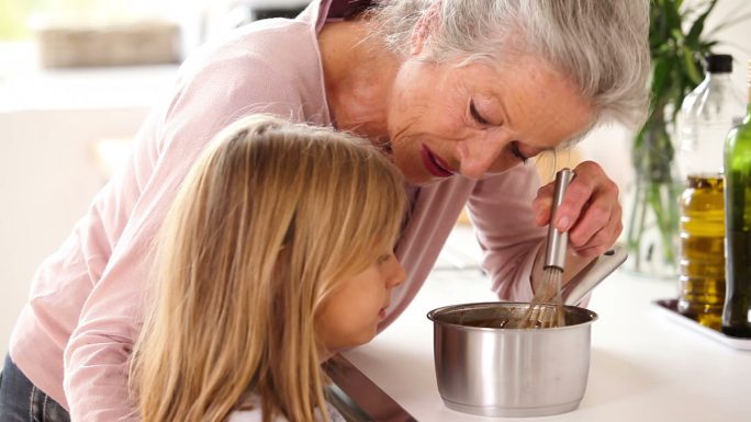 奶奶和小女孩在厨房里一起做巧克力酱