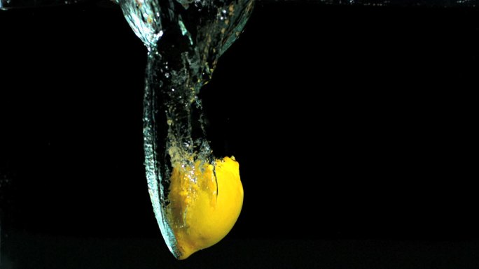 柠檬落在水中的黑色背景慢镜头