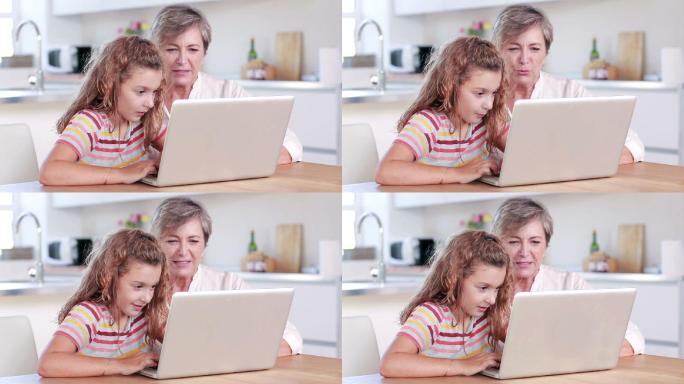 孩子和奶奶在厨房用笔记本电脑