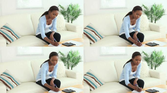 一名黑人妇女在客厅里使用计算器的视频