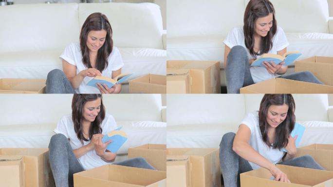 一个女人在起居室的移动盒子里看书的视频