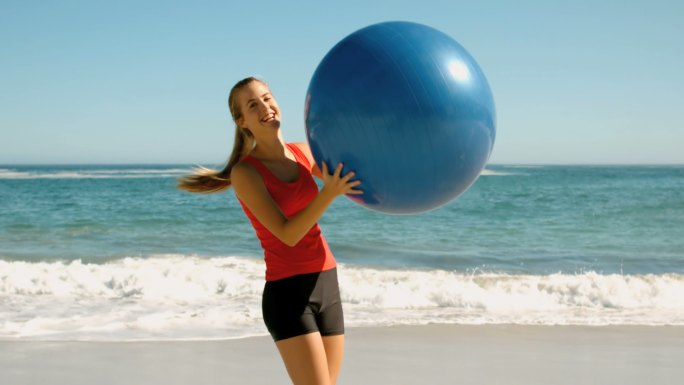 女人穿着运动服在沙滩上玩球特写
