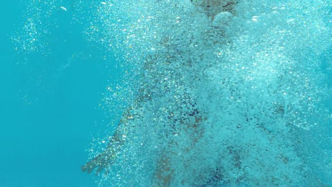 褐发女人在水下漂浮在蓝色泳衣在慢动作
