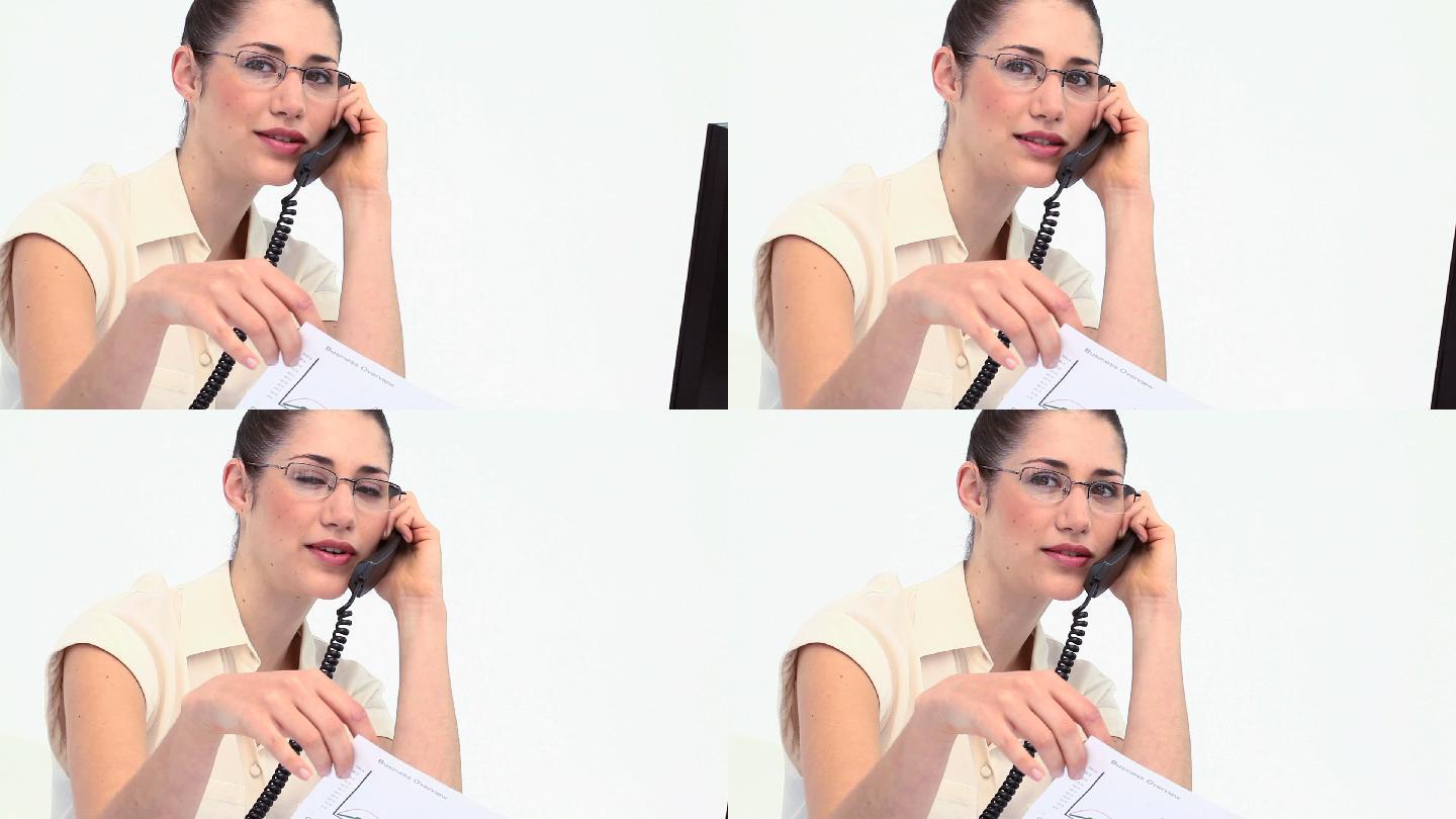 戴眼镜的女人在办公桌前打电话特写
