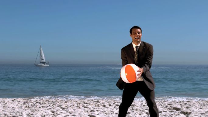 有魅力的商人在慢镜头里玩沙滩球