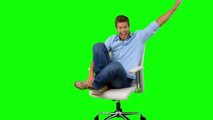 绿色背景下男人坐在椅子上举手欢呼特写