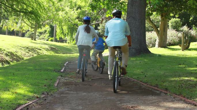 一家人一起在公园骑自行车特写