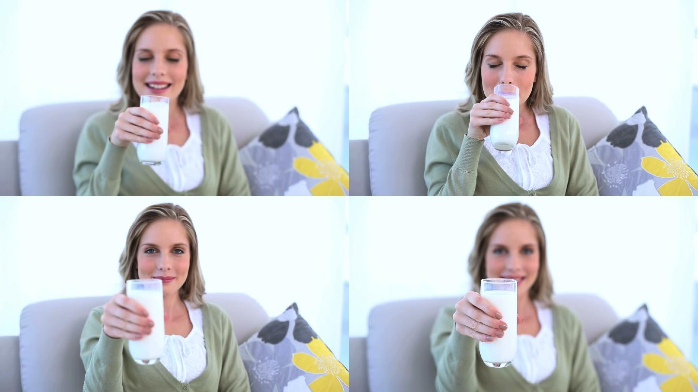 一个女人坐在沙发上喝牛奶特写