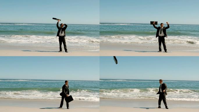 快乐的商人把手提箱扔在沙滩上的慢镜头