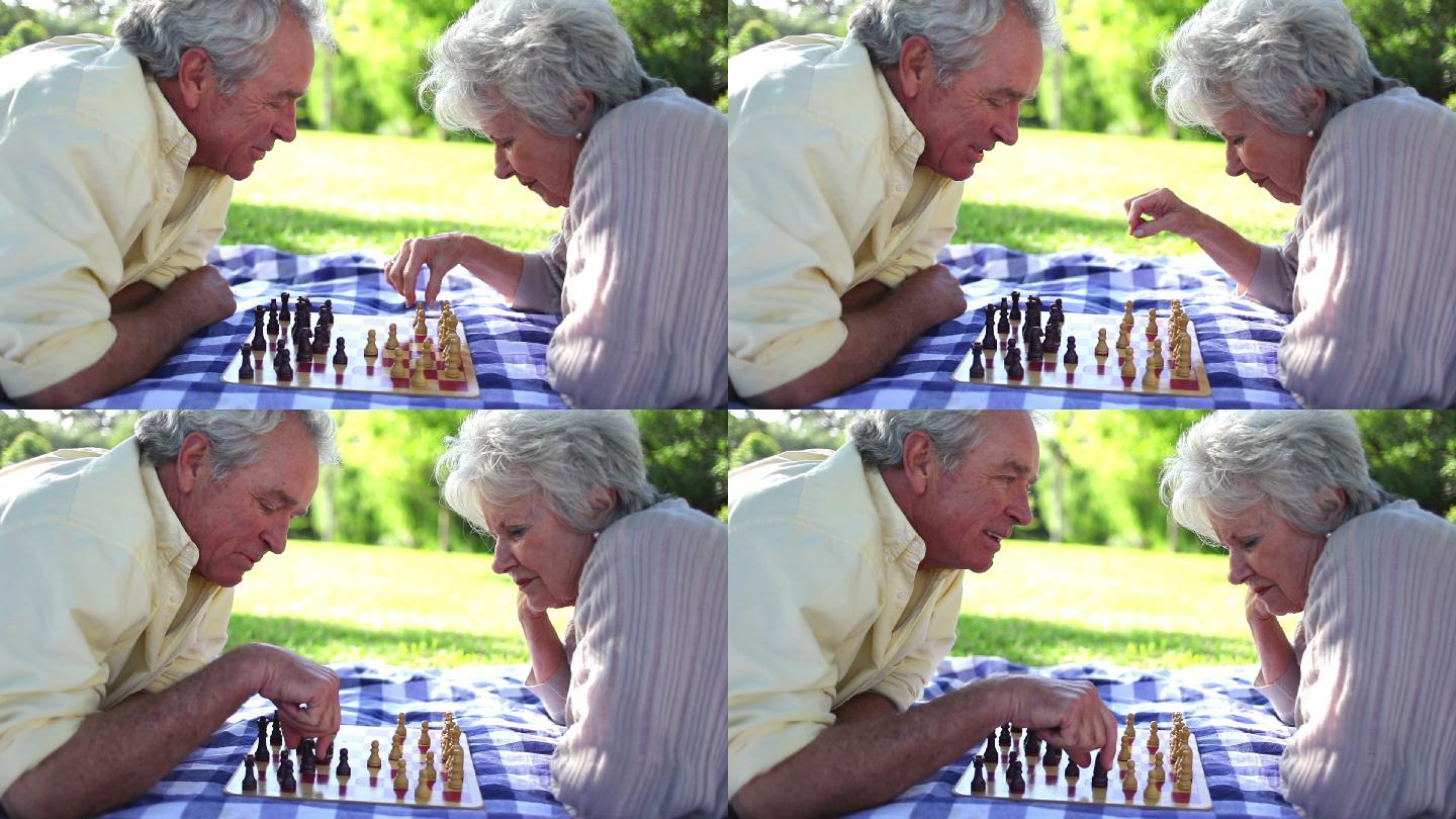 老夫妇在公园里下棋特写