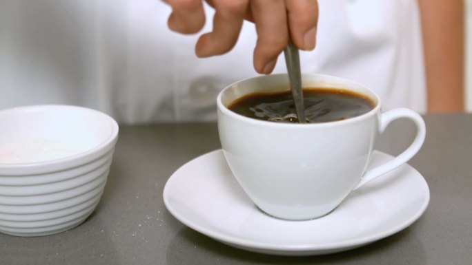 用手搅拌咖啡杯，以慢动作靠近