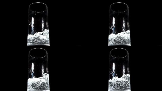 黑色背景下水被倒在杯子里特写