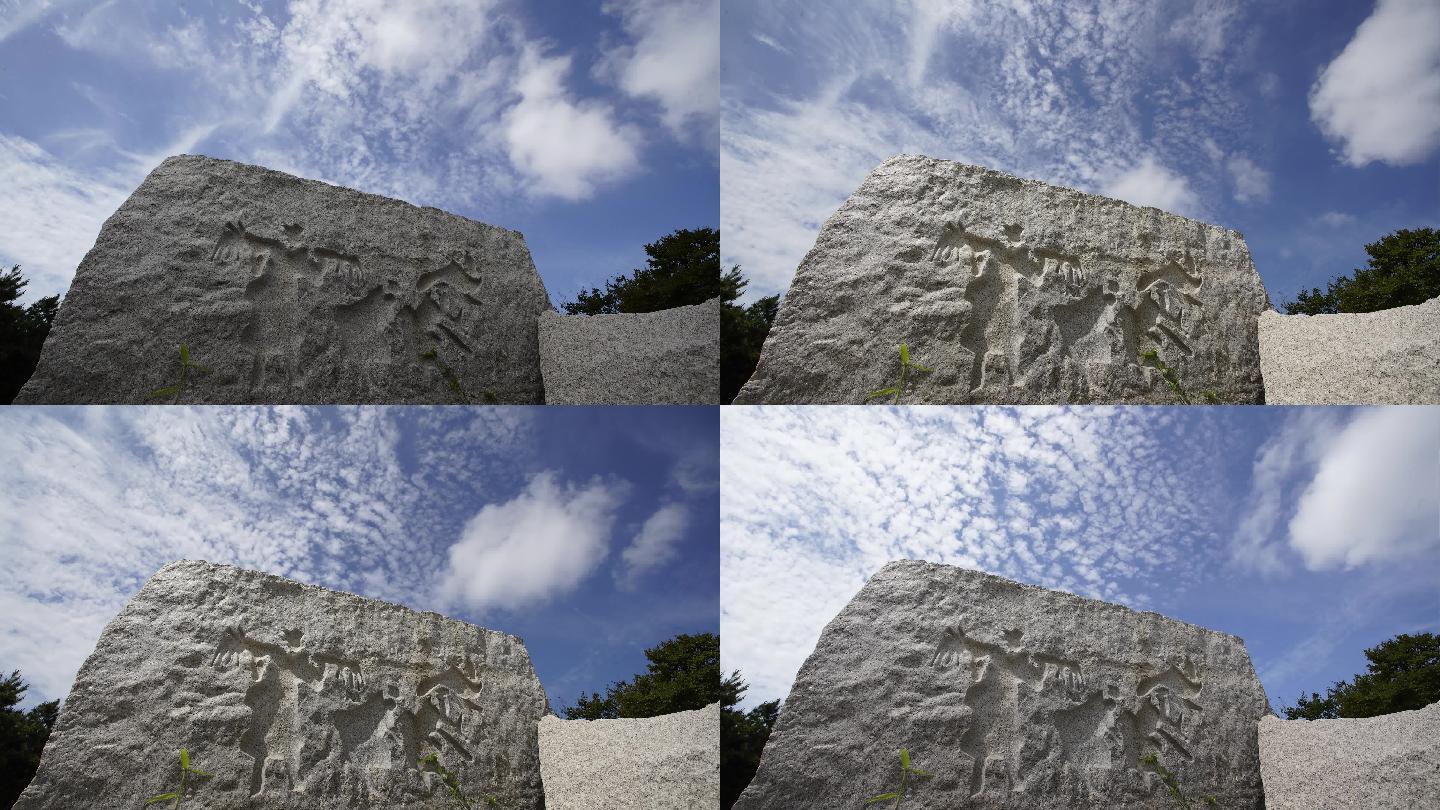 延时白云下的大石块雕刻