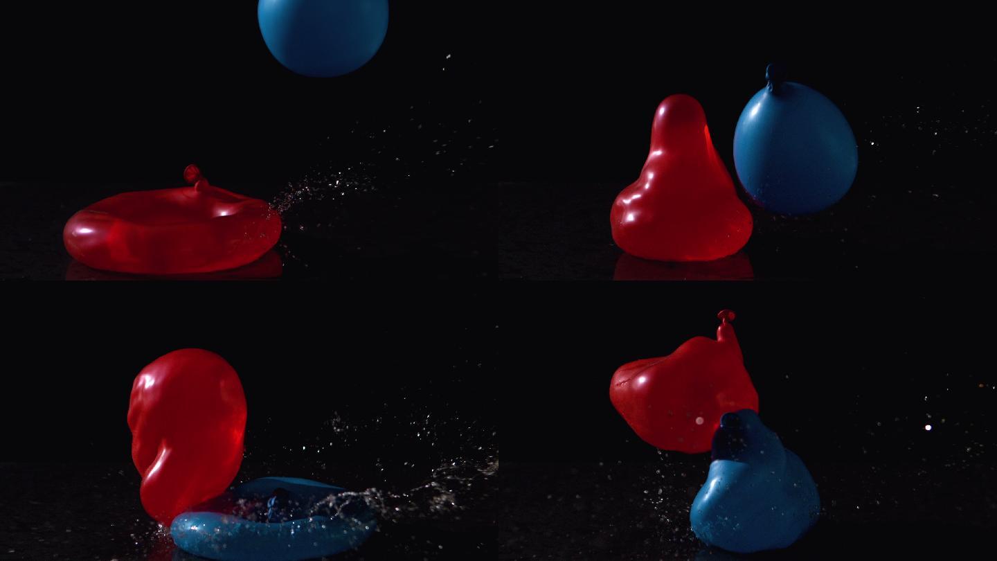 在慢镜头中，红色和蓝色的水球落在黑色背景上