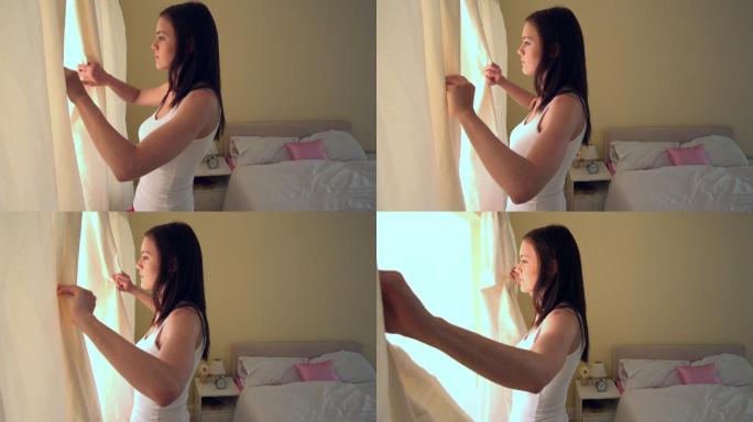 一个年轻女子在早晨拉开她卧室的窗帘，慢镜头