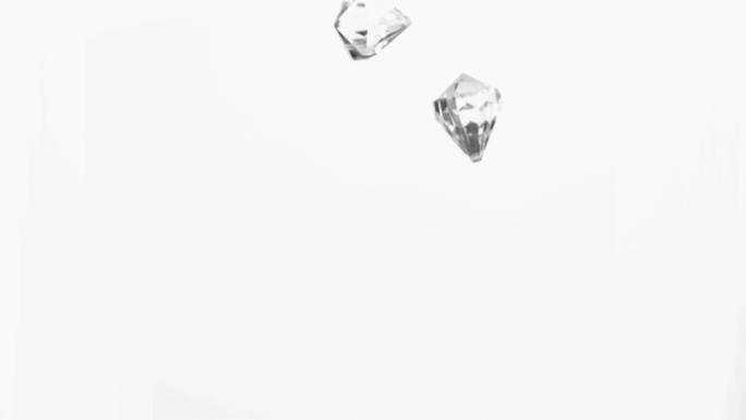 两颗钻石在白色背景下掉落下来特写