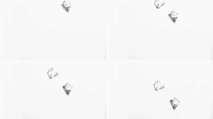 两颗钻石在白色背景下掉落下来特写