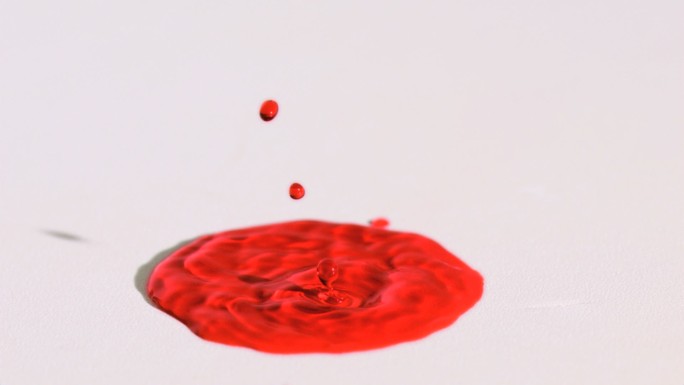 红色液体在白色背景下以超慢的动作飞溅