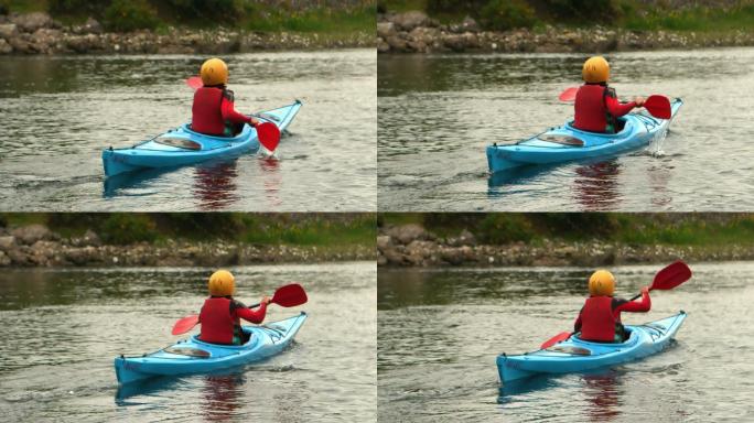 一名女子在河中划皮划艇，远离镜头的慢镜头