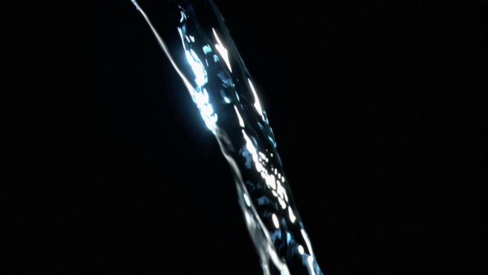 近距离观察，一股水流以超慢的动作在黑色背景下闪烁着蓝色的光芒