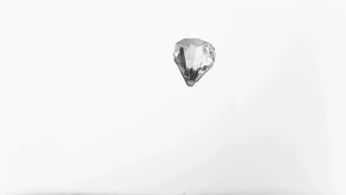 一颗钻石在白色背景下掉落下来特写