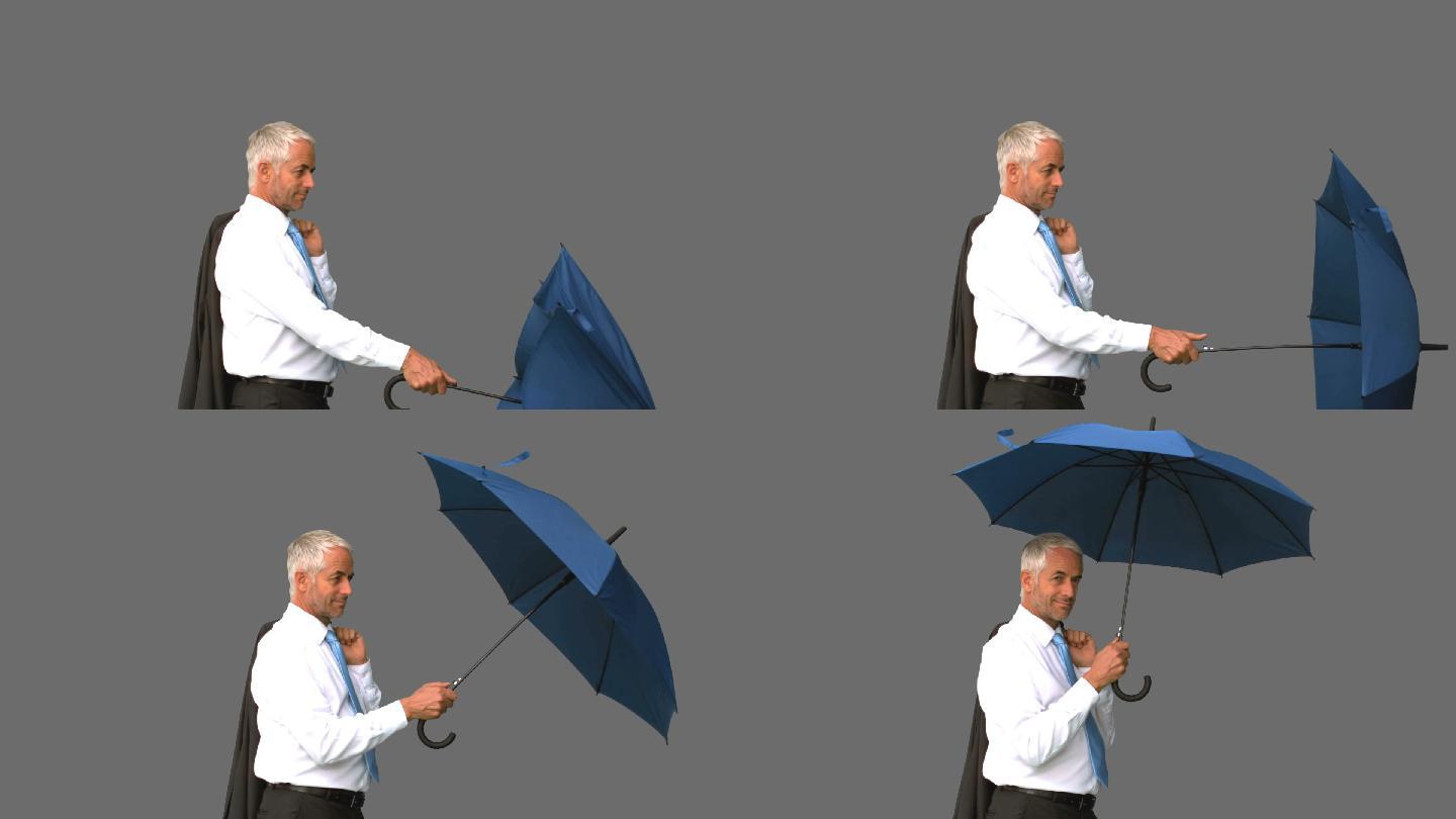 商人在灰色背景下打开雨伞特写