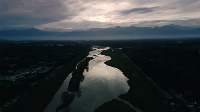 夕阳下流淌的河流 山脚下的河流流向远方