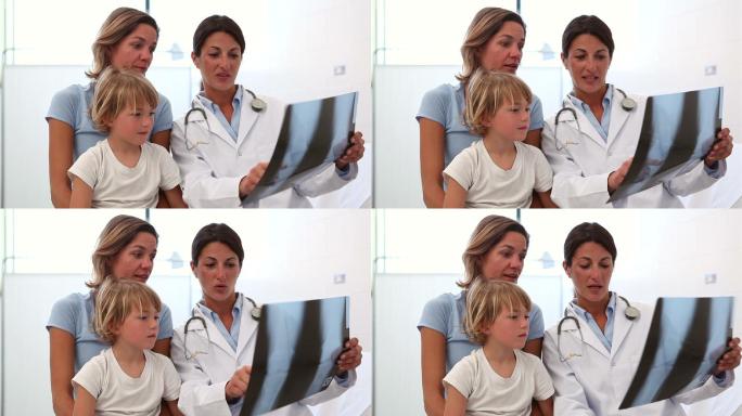 医生在诊室里给妈妈看孩子的x光片特写