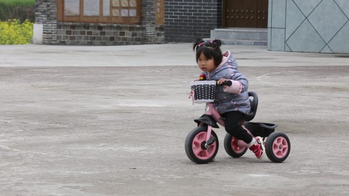 农村小女孩道地上骑自行车实拍素材