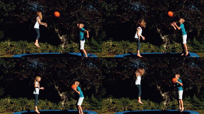 欢快的兄弟姐妹在玩篮球的同时在蹦床上慢动作跳跃