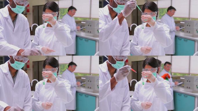 化学家们在实验室里观察烧杯里的液体特写