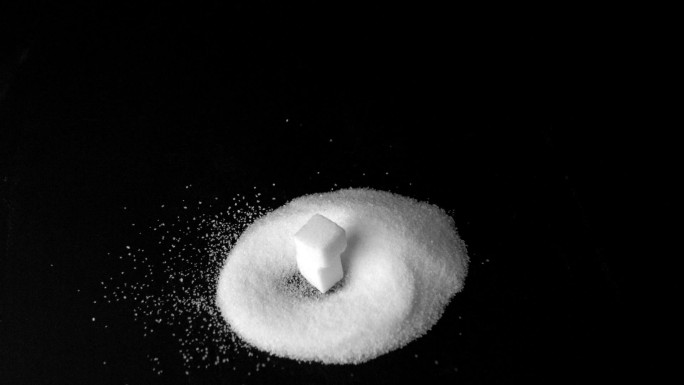 方糖掉落在糖粉上特写