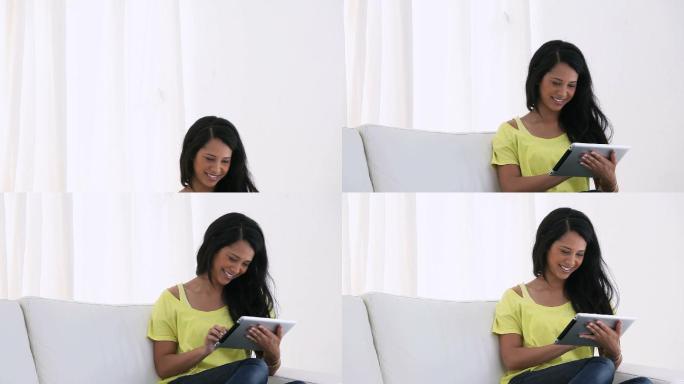 一个女人坐在沙发上看电子书的视频