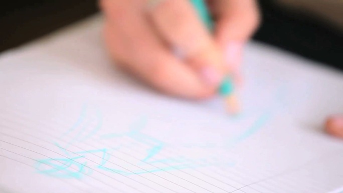 近距离看一个女人用彩笔在笔记本上画画