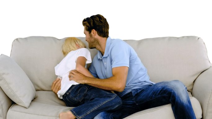 父亲在沙发上给儿子搔痒，慢动作的白色背景