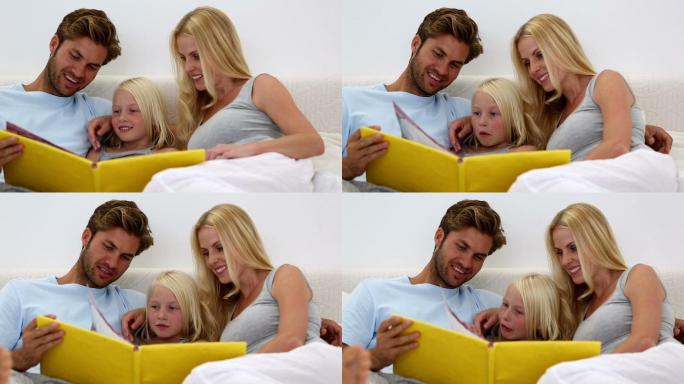 父母和女儿一起在家里的床上看书