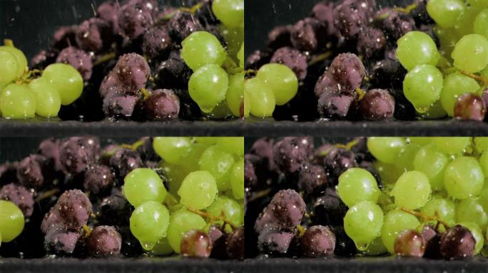 以超慢镜头拍摄葡萄在黑色背景下接受水