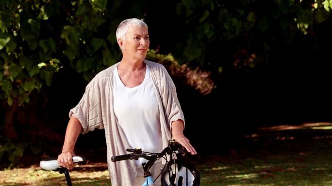 迷路的女人骑着自行车在公园里散步特写