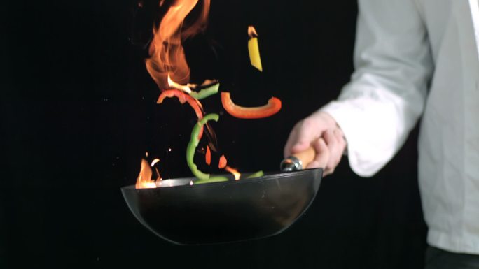 一个厨师在用大火炒菜特写