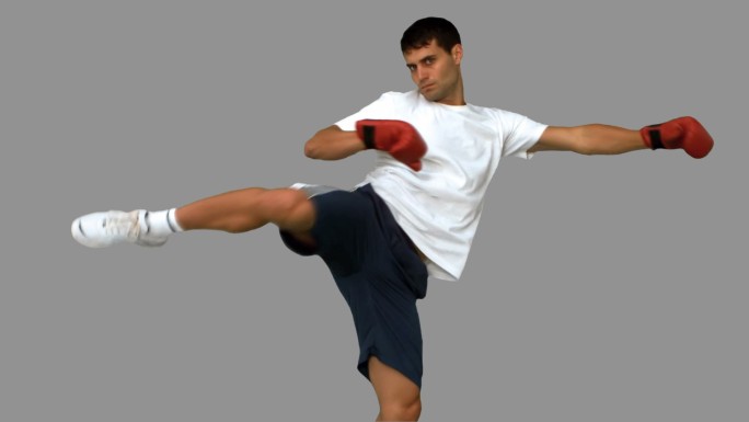 男人戴着拳击手套在灰色背景下打拳特写
