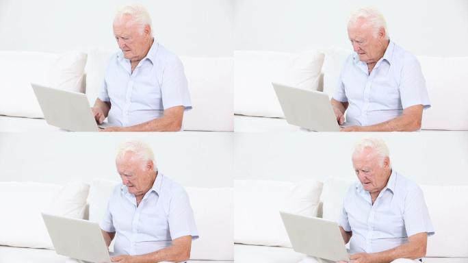 一个老人在客厅里用笔记本电脑
