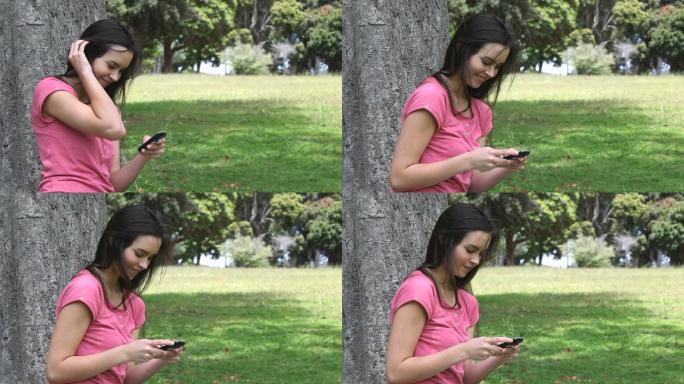 一个女人在公园里拿着手机特写