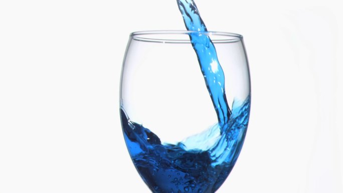 蓝色的涓涓细流以超慢的动作流淌在酒杯中，映衬着白色的背景