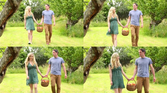 一对夫妇抱着装满苹果的篮子特写