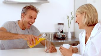 在慢镜头中，一个快乐的男人正在倒橙汁视频素材