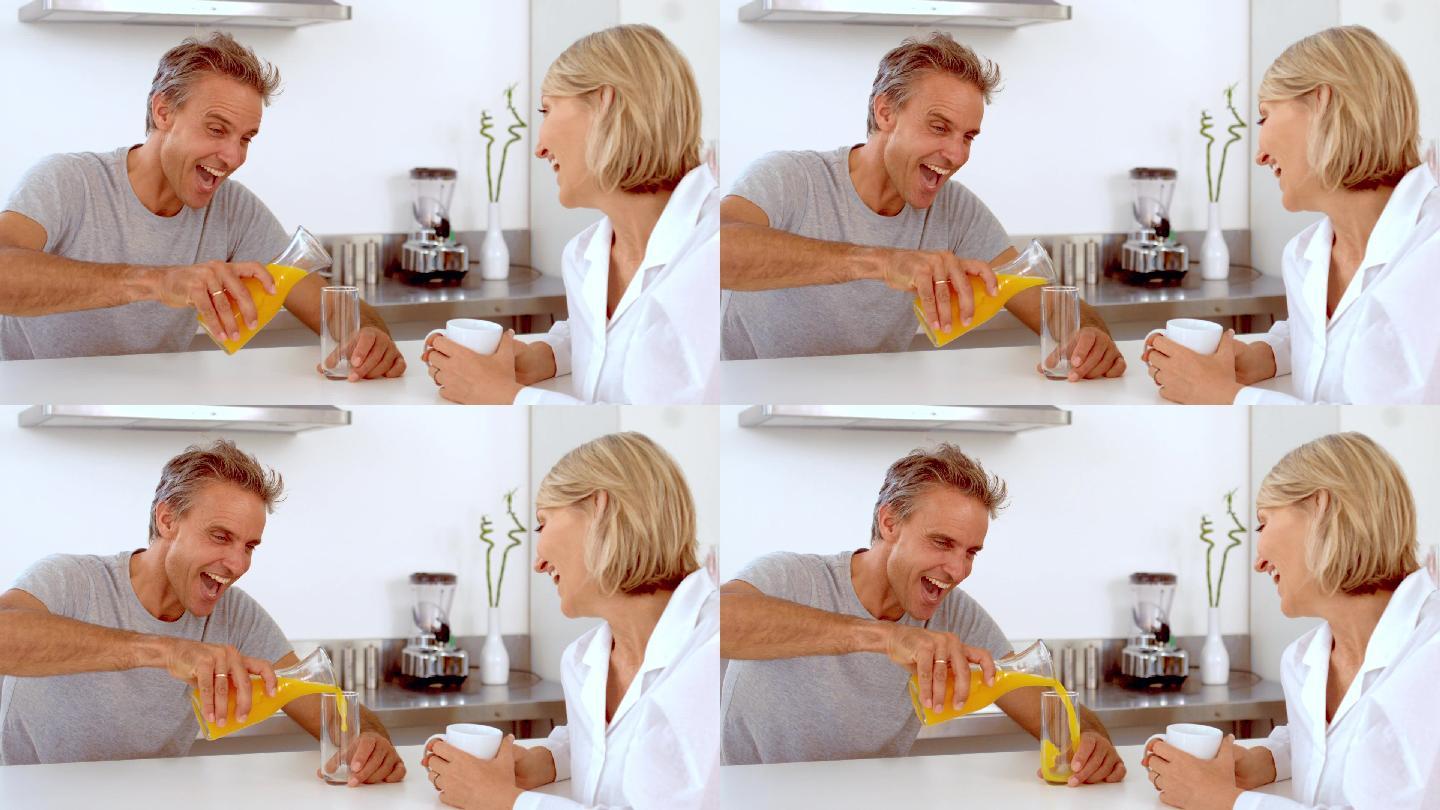 在慢镜头中，一个快乐的男人正在倒橙汁